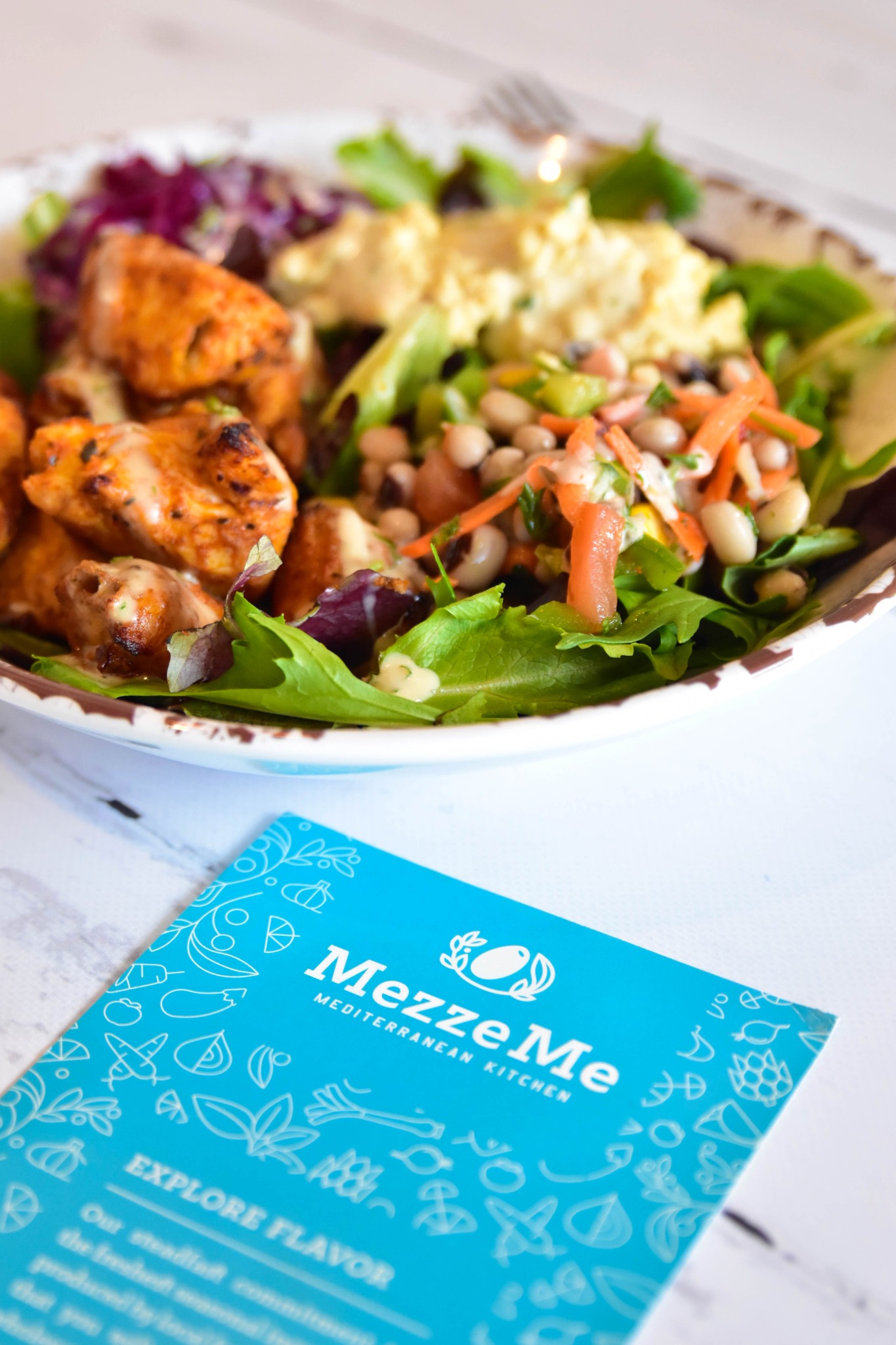 A colorful chicken and salad plate at MezzeMe