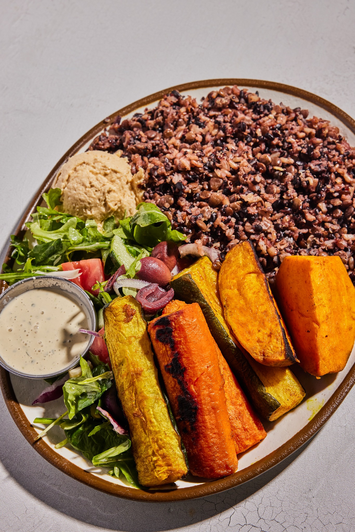 A colorful MezzeMe bowl with fresh vegetables and hummus